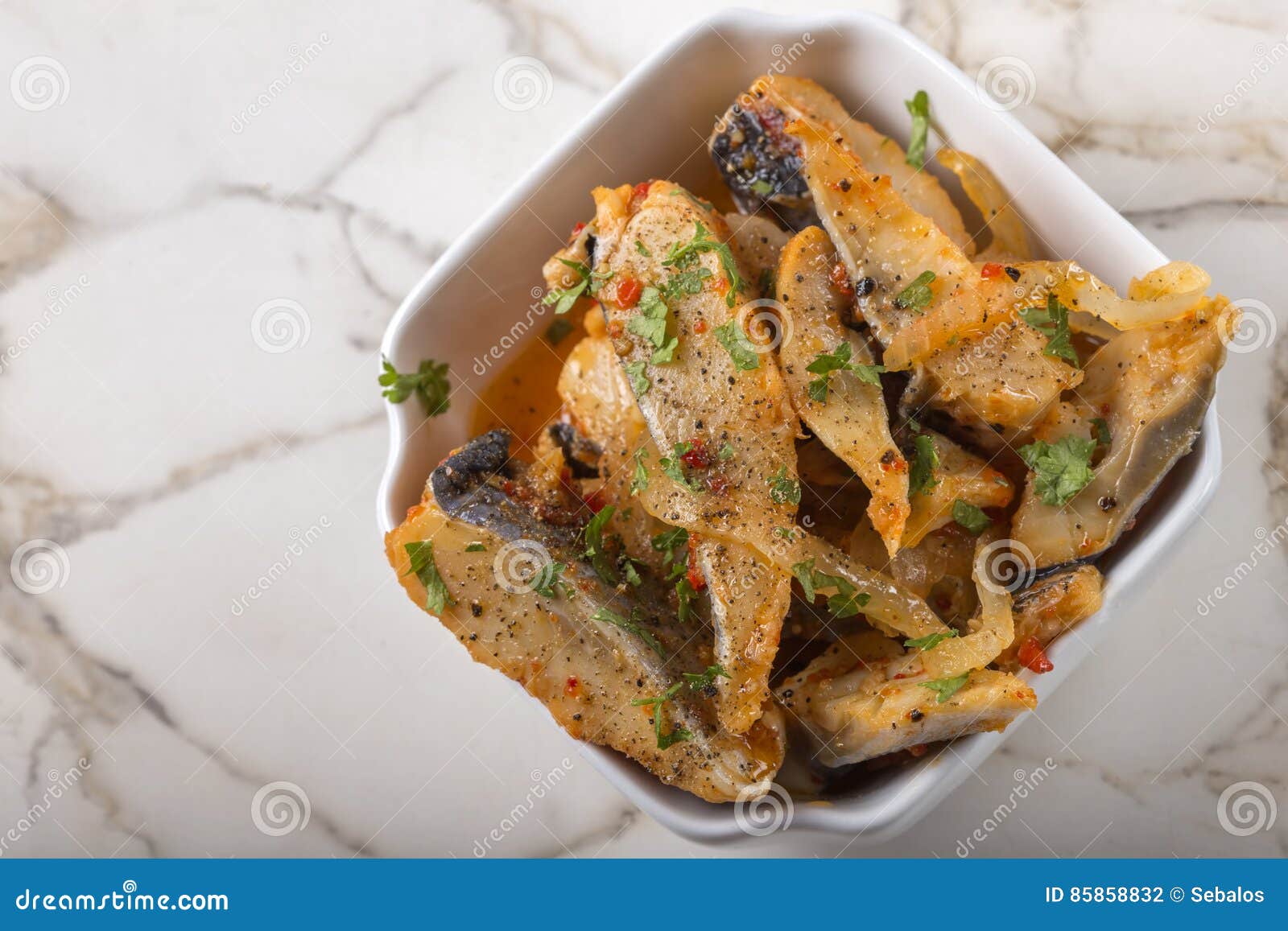 Marinated Herring Fish with Onion and Tomato Sauce in White Bowl Stock