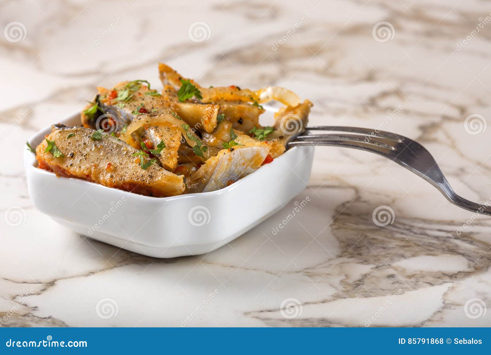 Marinated Herring Fish with Onion and Tomato Sauce in White Bowl Stock