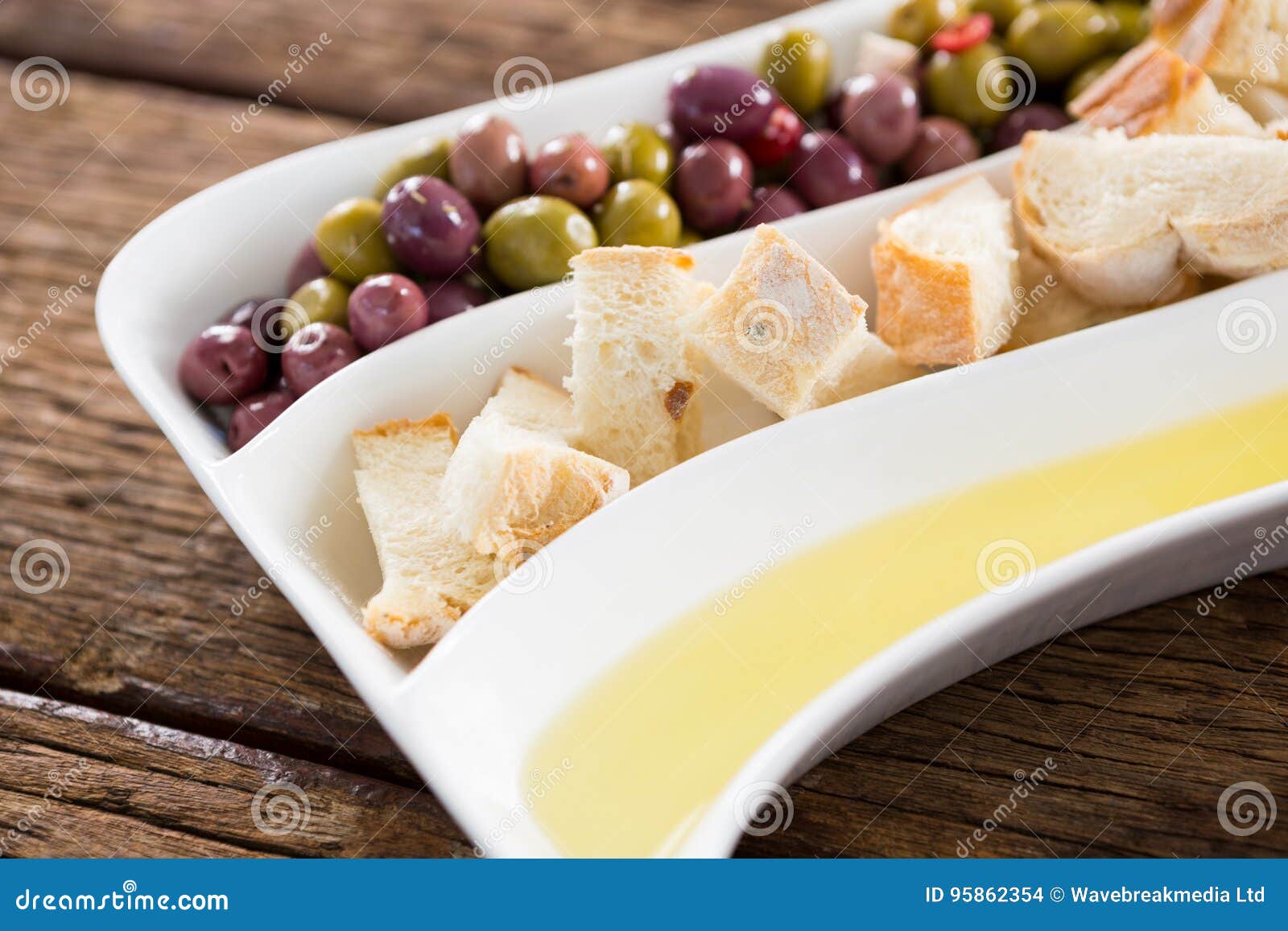 Marinated Olives, Bread Pieces and Olive Oil in Platter Stock Photo