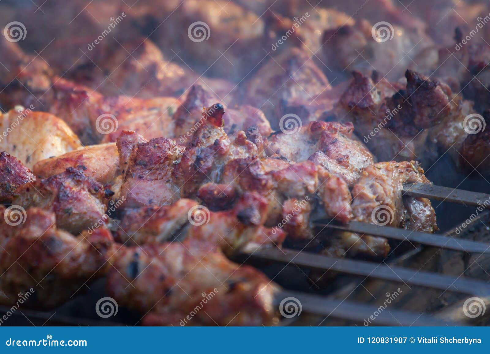 marinated shashlik preparing on a barbecue grill over charcoal. shashlik or shish kebab popular in eastern europe. shashlyk, skewe