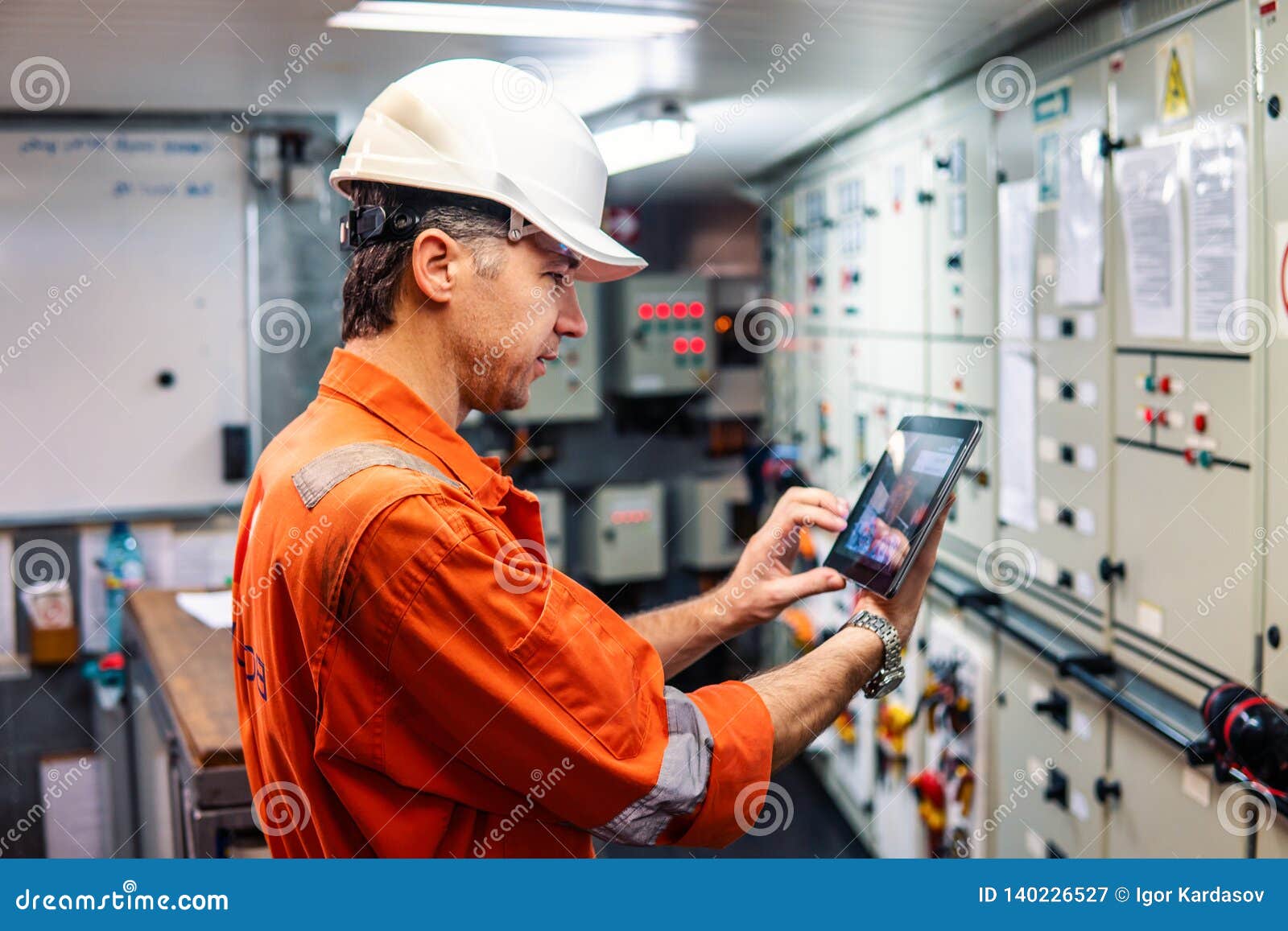 marine chief engineer watching digital tablet in engine control room