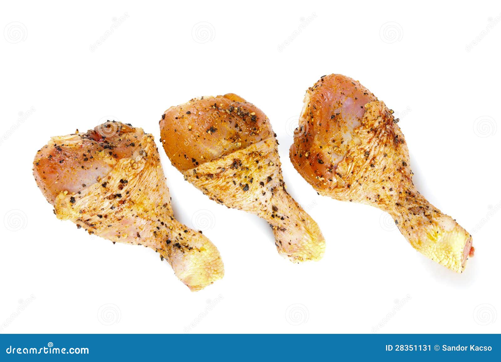 Marinierte Hühnerbeine auf Weiß. Drei rohe Hühnerbeine getrennt auf Weiß.
