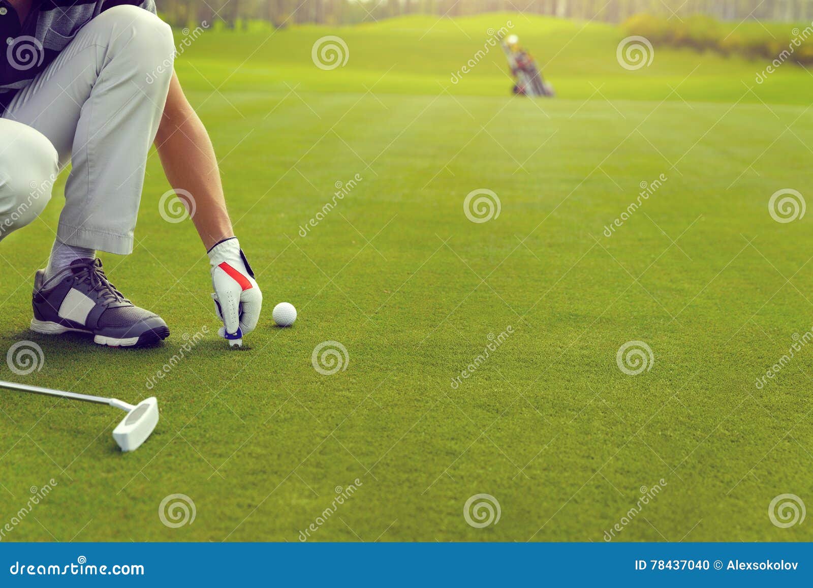 Marking golf ball position on the green. Male golfer marking ball position on the green. Focus on pitchmark