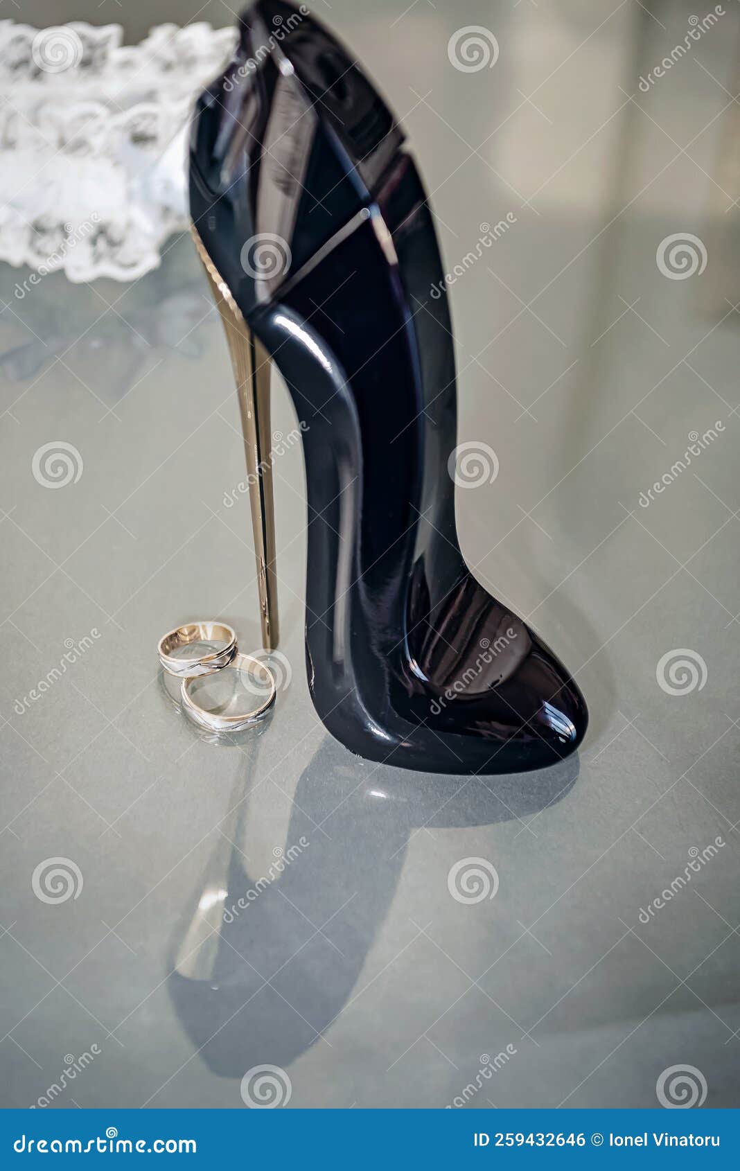 Marriage Rings with Decorative Shoe on Glass Table and Reflections
