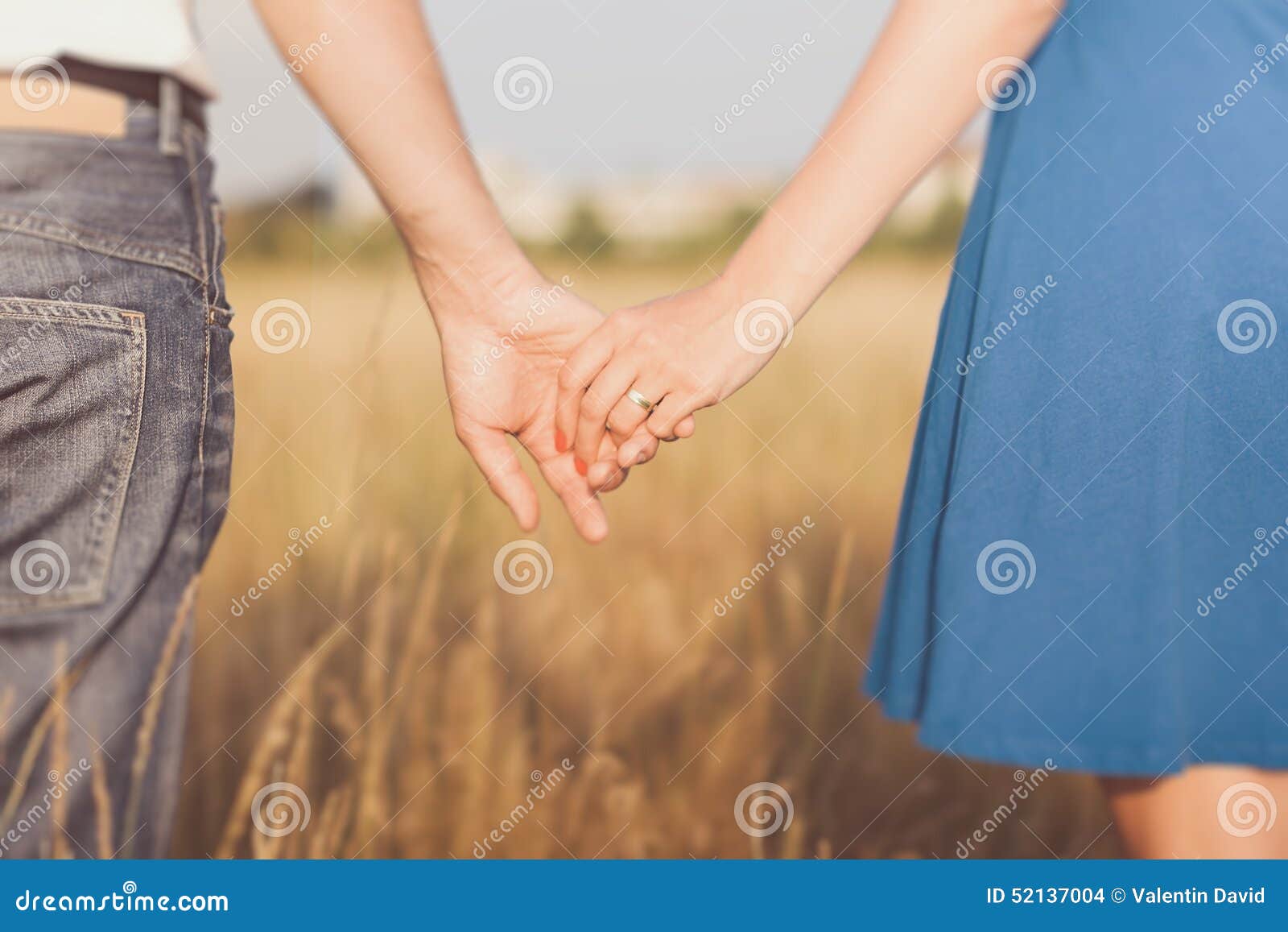 married couple holding hands at sunset