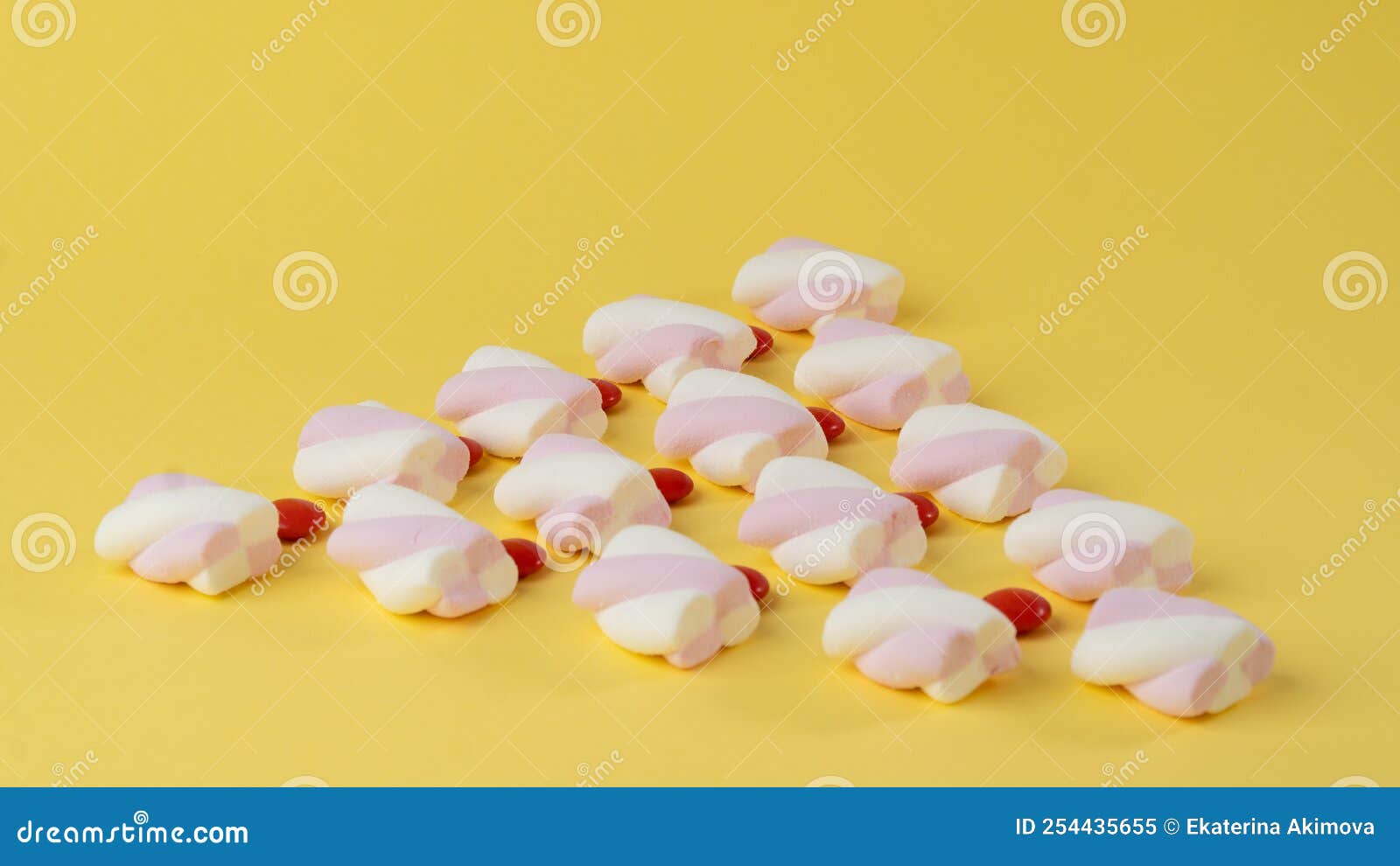 Marshmallows and Red Candy Dragees in the Form of a Triangle on a