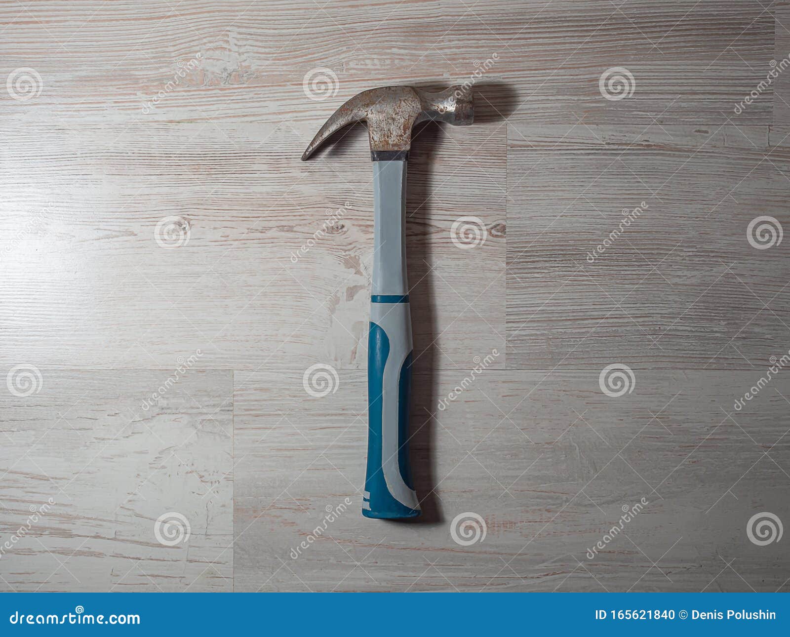 Martillo de construcción sobre el suelo Un viejo martillo de hierro oxidado gris de color azul se encuentra sobre un fondo claro de madera, trabajando, suelo, reparación, golpe