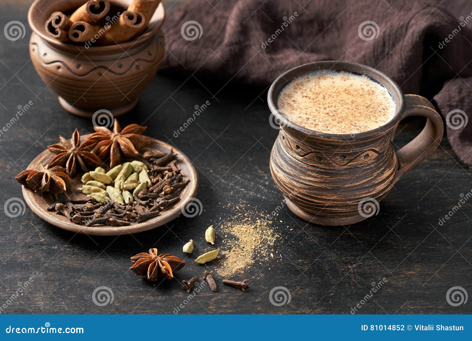 masala pulled tea chai latte hot indian sweet milk spiced drink, cinnamon stick, cloves, fresh spices and herbs blend