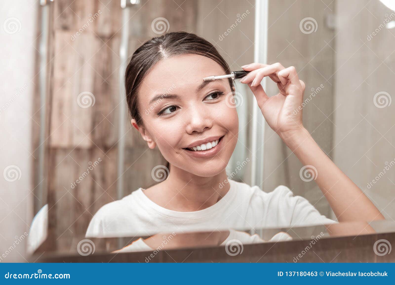 Darkhaired Businesswoman Using Gel Mascara for Eyebrows Stock Image