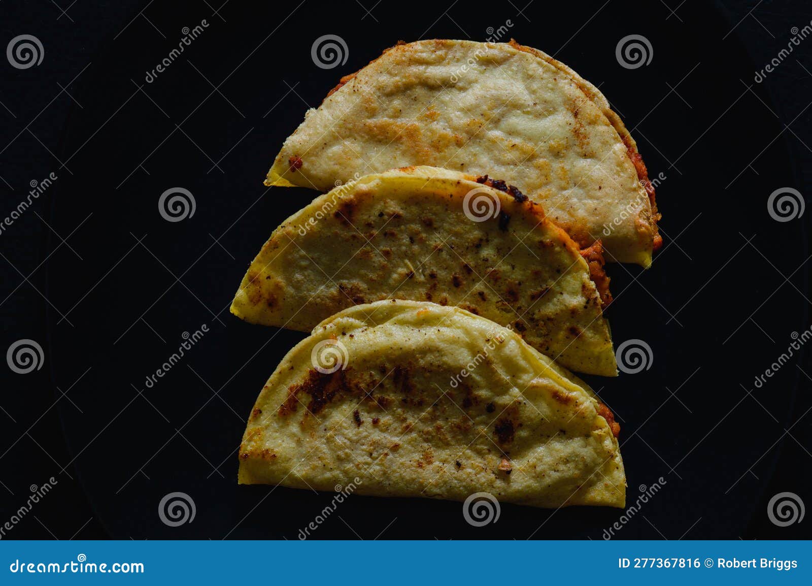 mashed potato and chorizo tacos dorados on black background