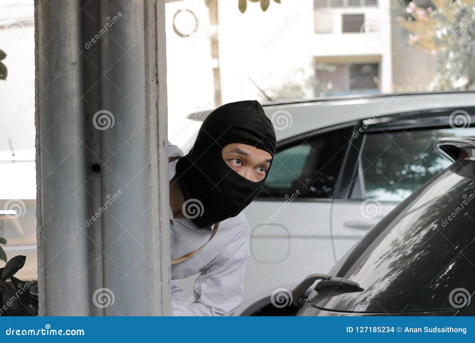 Masked Burglar Wearing A Balaclava Ready To Burglary Against Car Background Insurance Crime