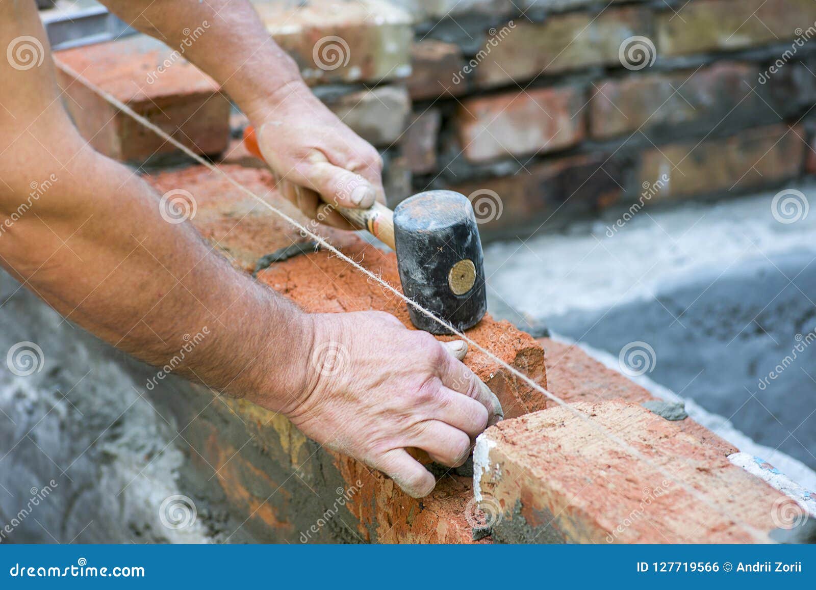 Mason Making Wall with Mortar and Bricks, Using Hammer Tool. Industrial