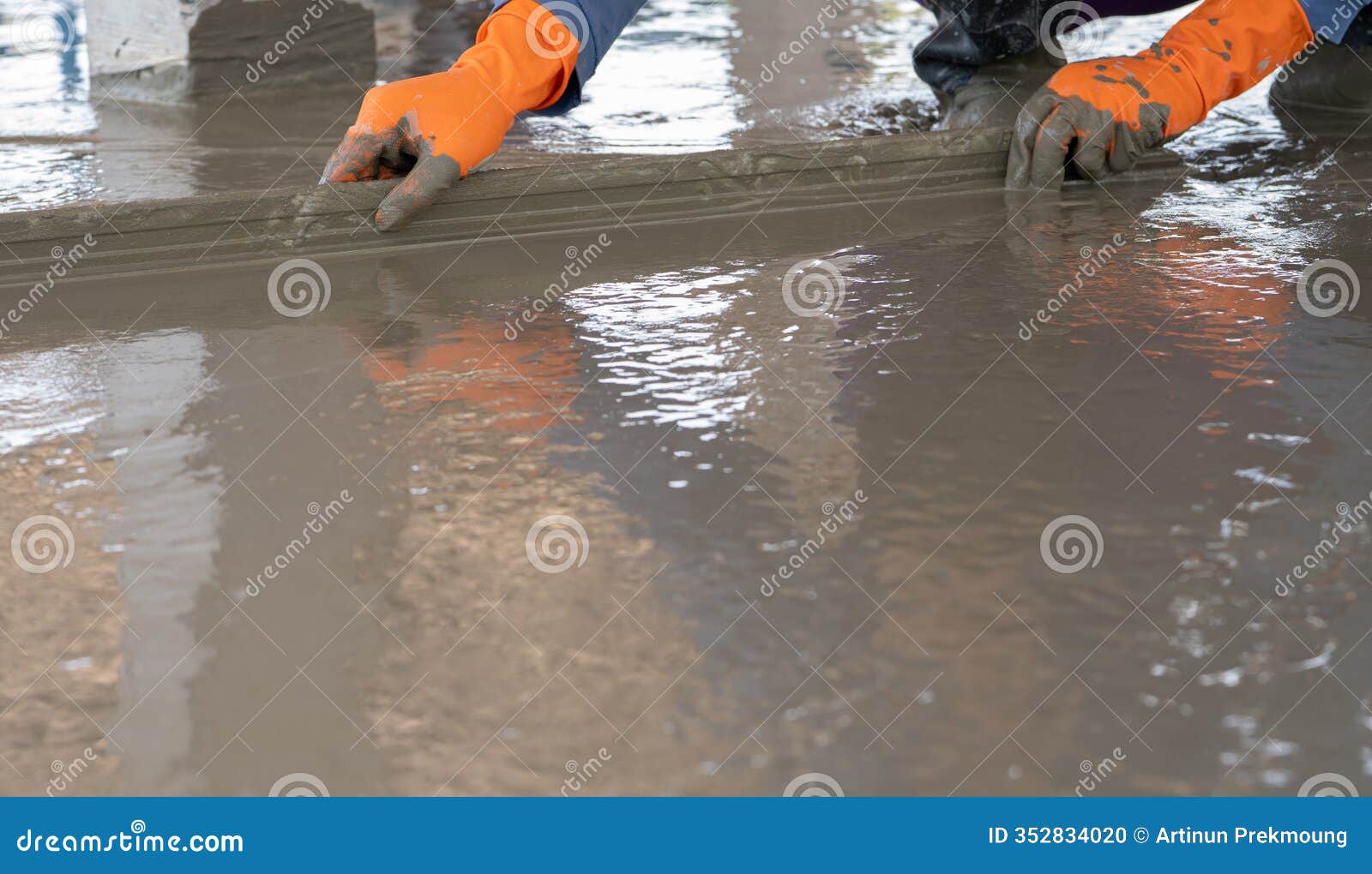 mason worker working with trowel to level cement floor at construction site. a skilled construction worker spreading wet concrete
