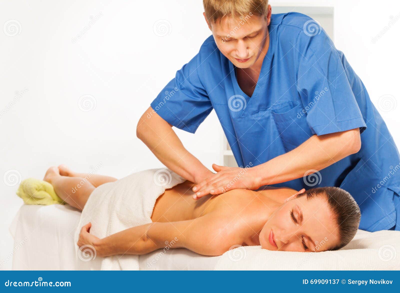 masseur doing massage on woman body in spa salon
