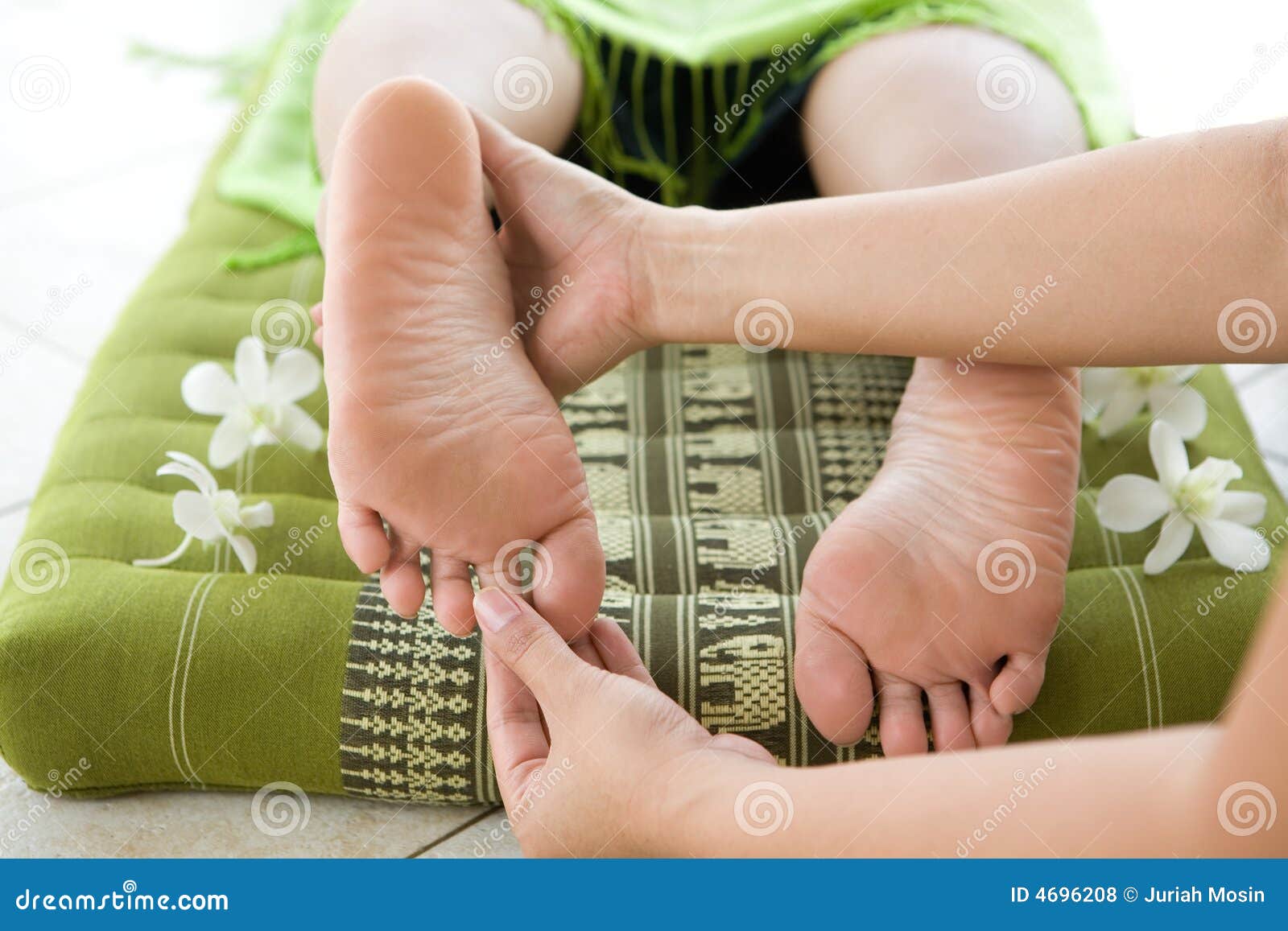 masseur giving female patient a foot reflexology.