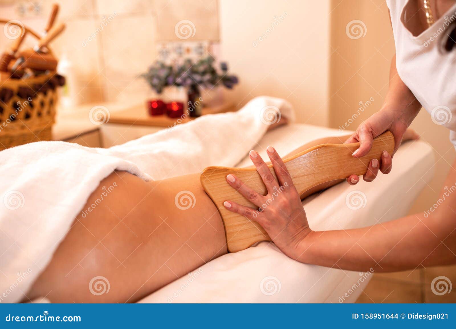 masseuse holding a hand held wooden massage tool