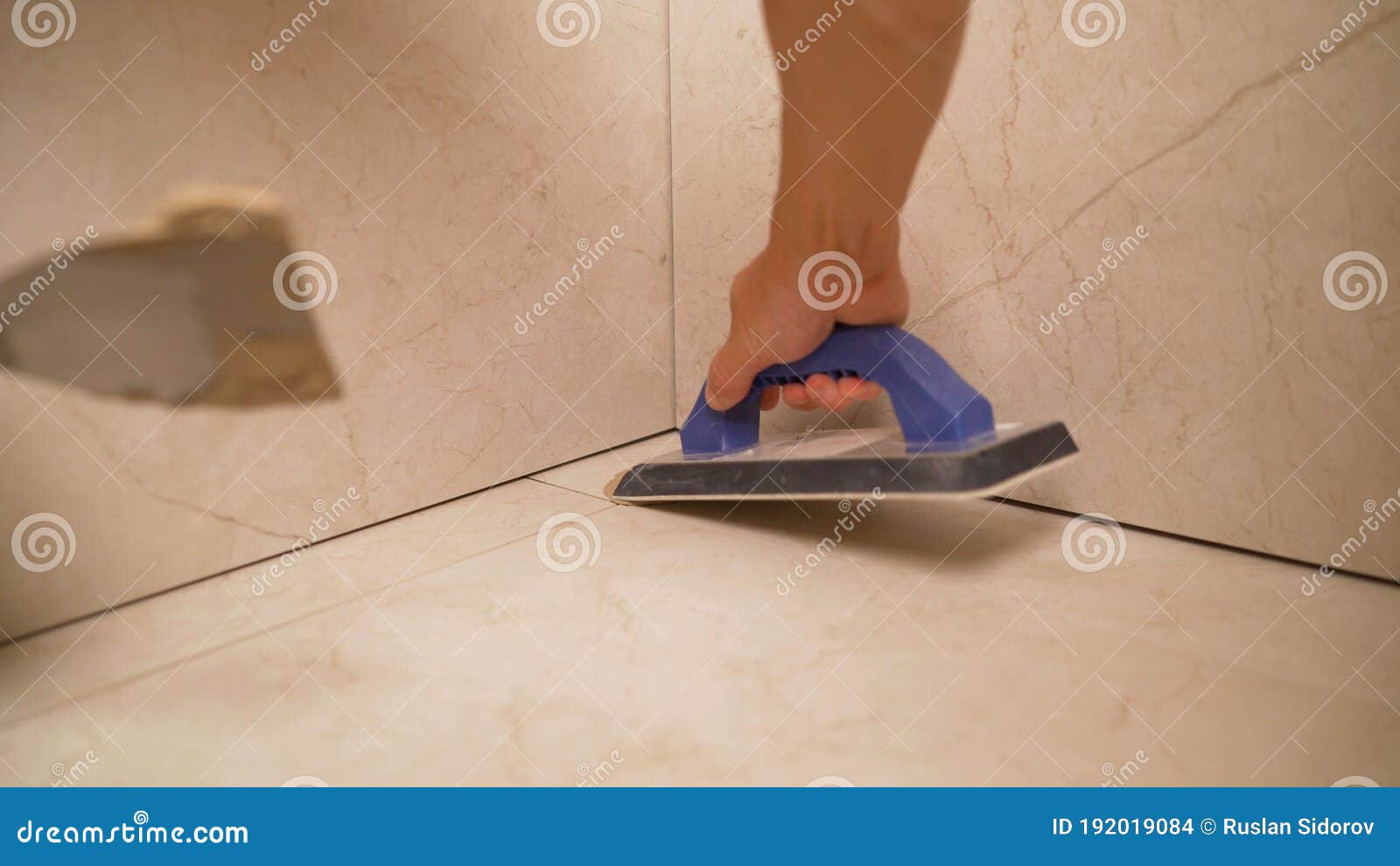 The Master Cleans the Joints between the Tiles in the Bathroom