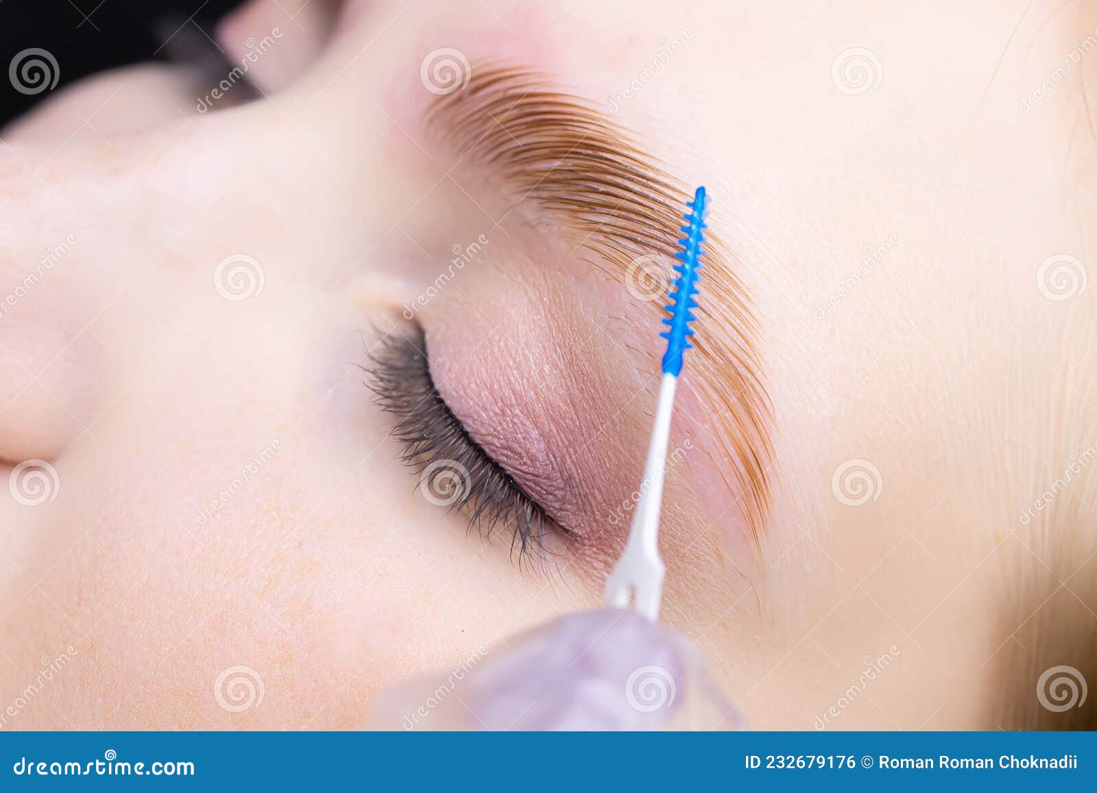 the master combs the eyebrows with a special brush after the eyebrow lamination procedure