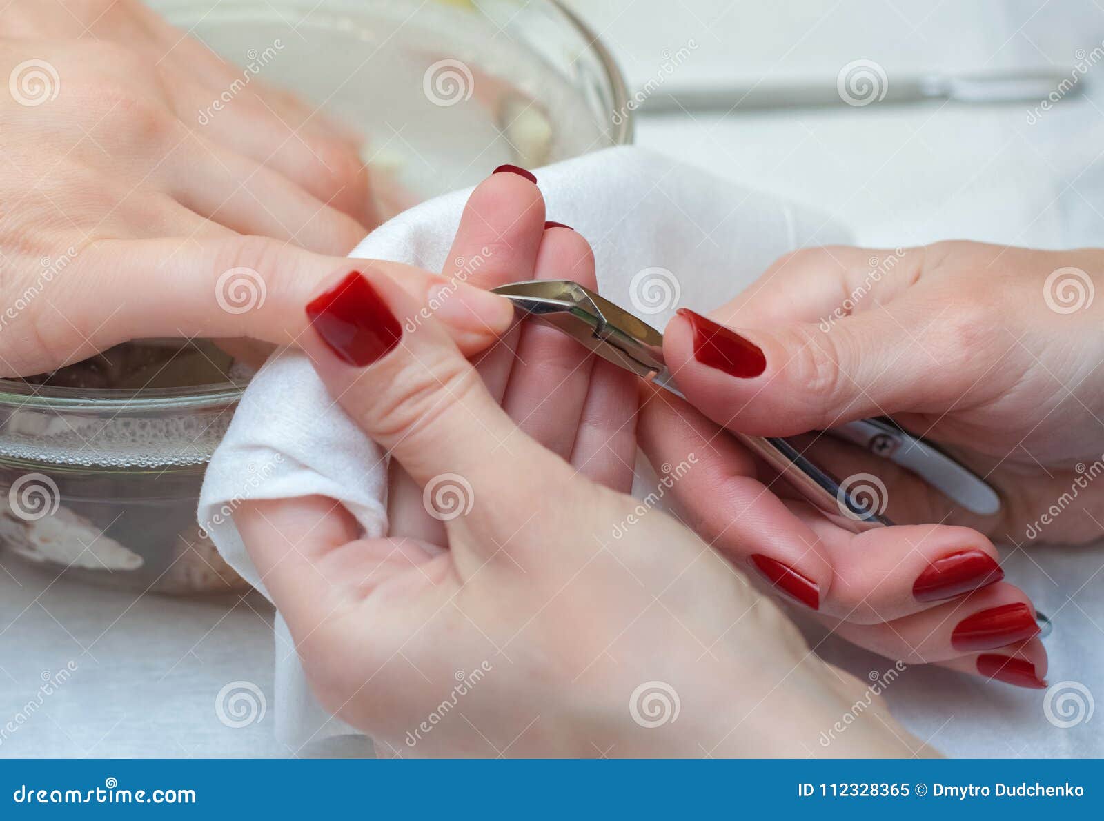 the master of the manicure cuts the cuticles on the hands in the beauty salon.