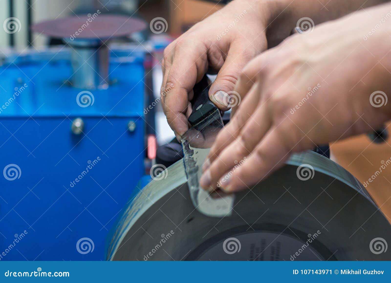 Master Sharpening a Knife with a Black Handle for Grinding Machine