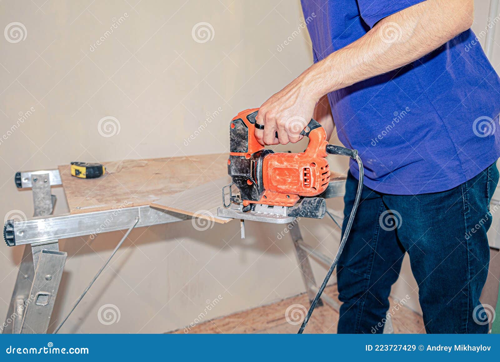 The Master Uses a Jigsaw To Cut the Laminate on the Workbench Stock