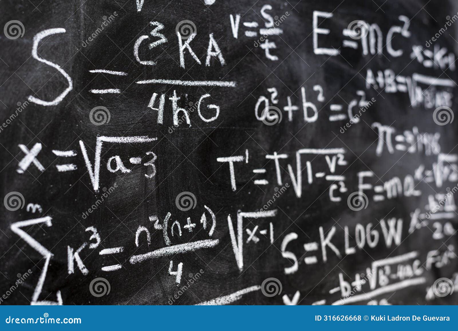 mathematical equations and physics formulas handwritten on blackboard