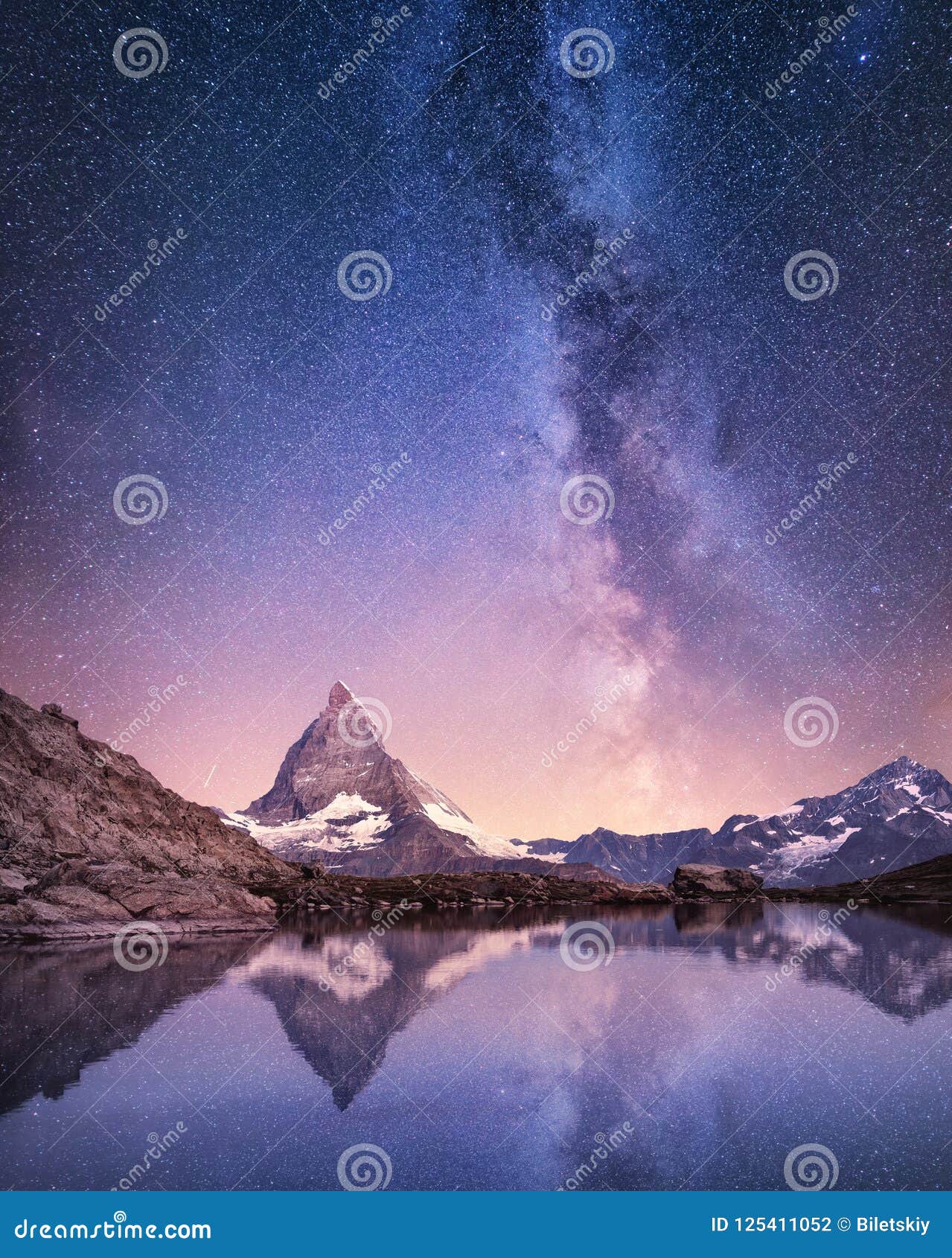 matterhorn and reflection on the water surface at the night time. milky way above matterhorn, switzerland.