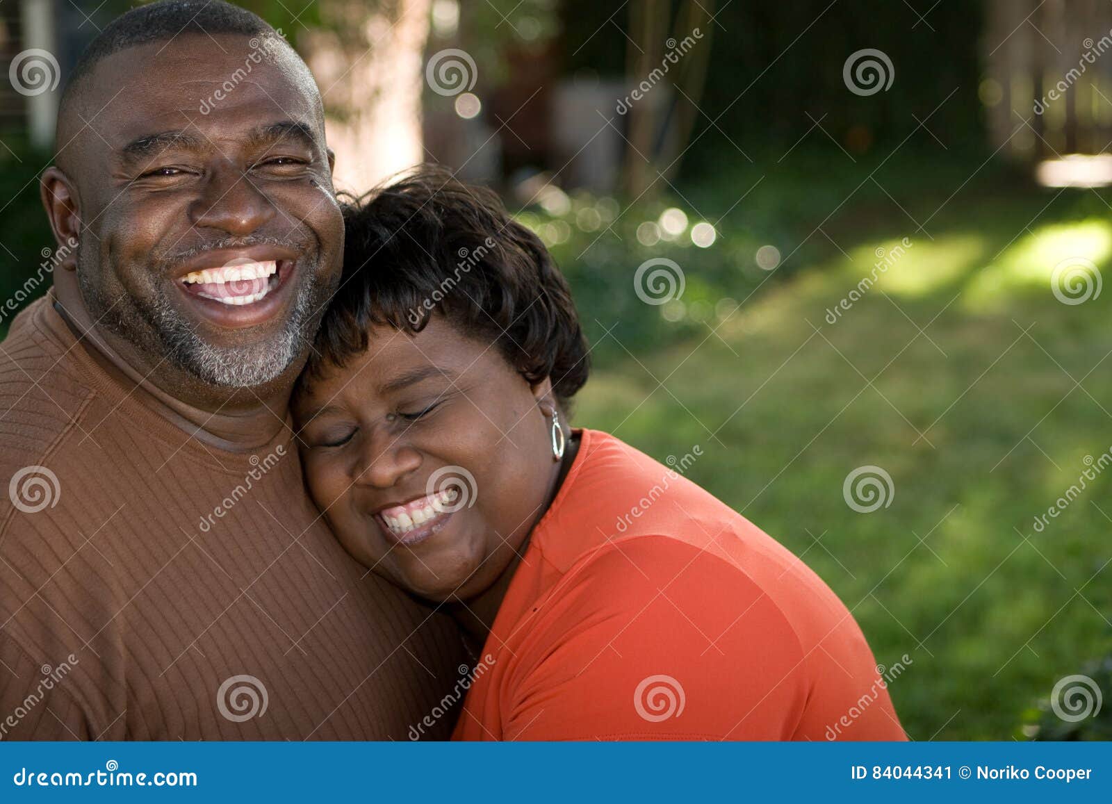 mature african american couple laughing and hugging.
