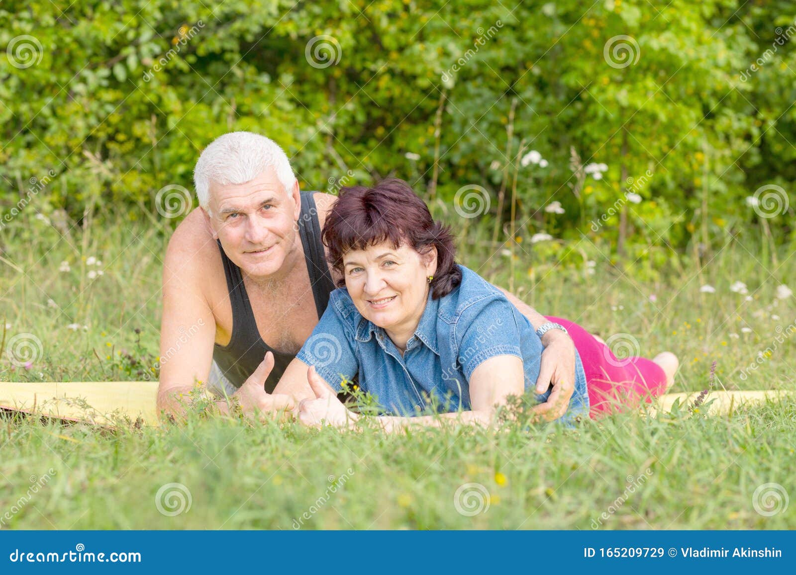 Mature Beautiful Couple In Love Lie On A Sports Mat On A Green Lawn In 
