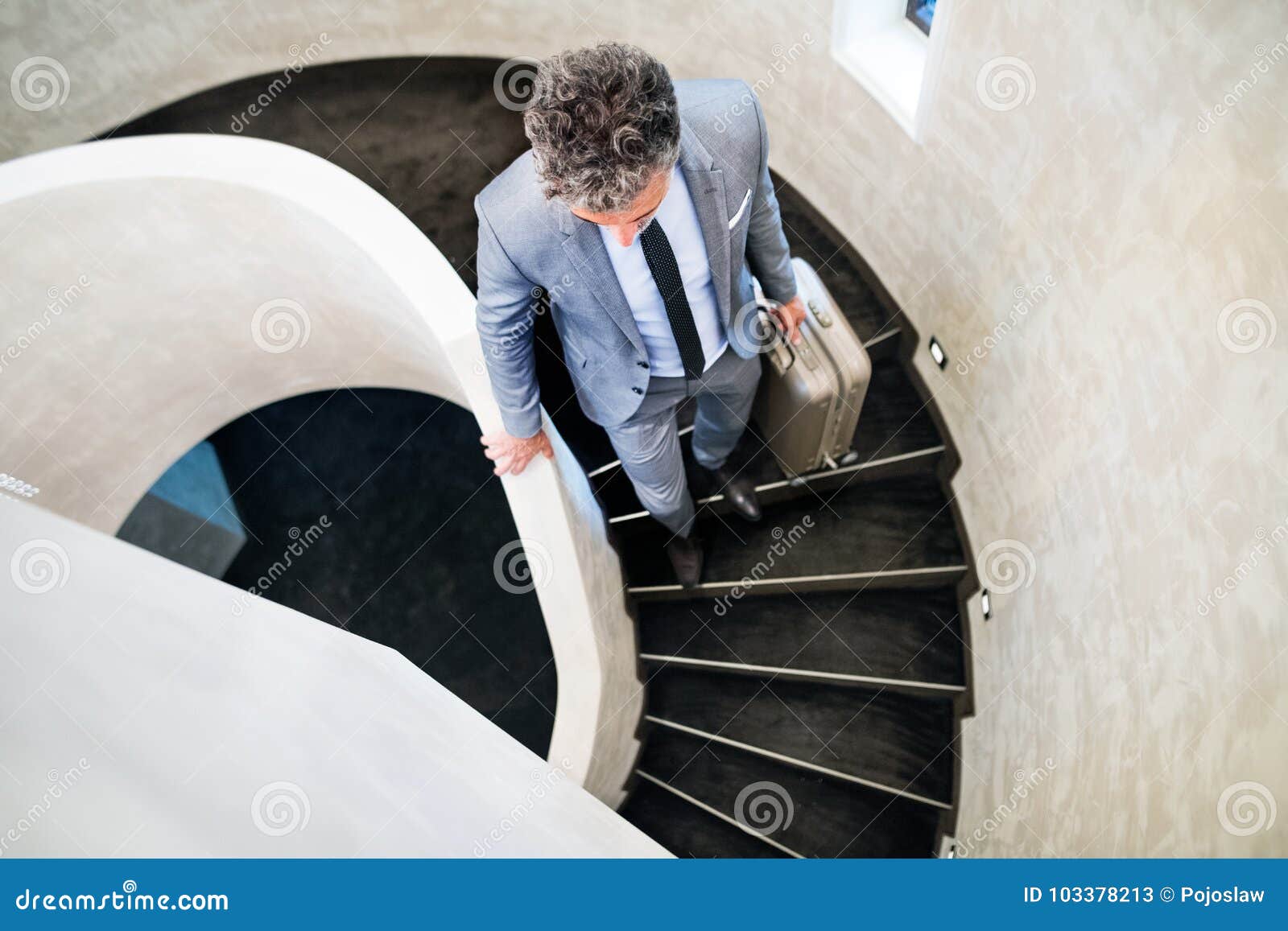 Businessman with Suitcase Walking Down the Stairs. Stock Image - Image