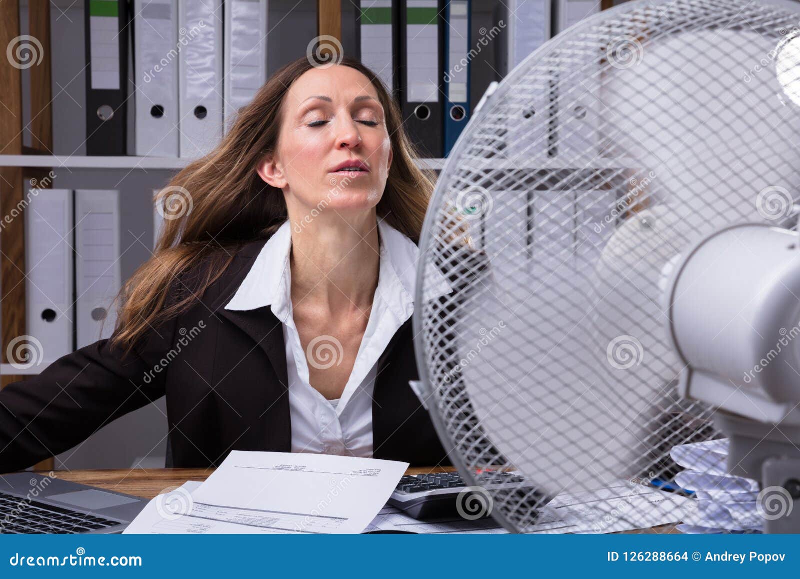 Businesswoman Cooling Herself In Front Of Fan