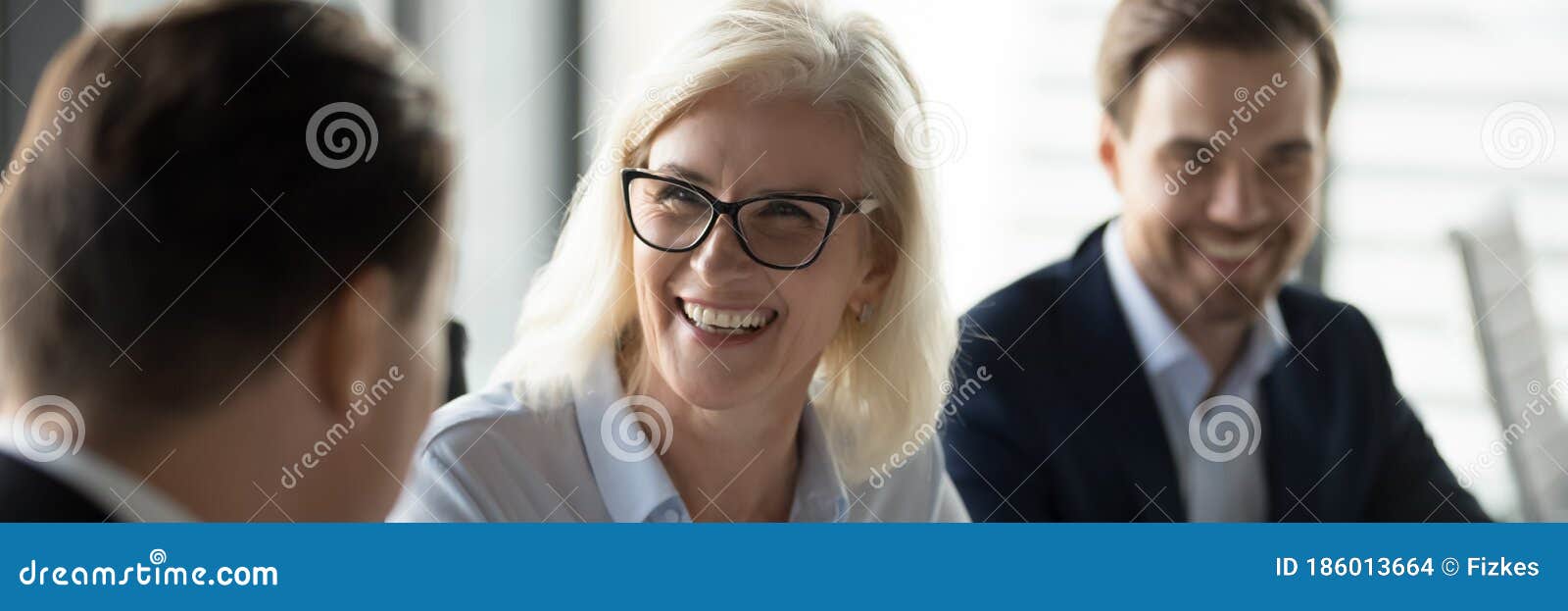 middle aged businesswoman laughing enjoy friendly talk during business meeting