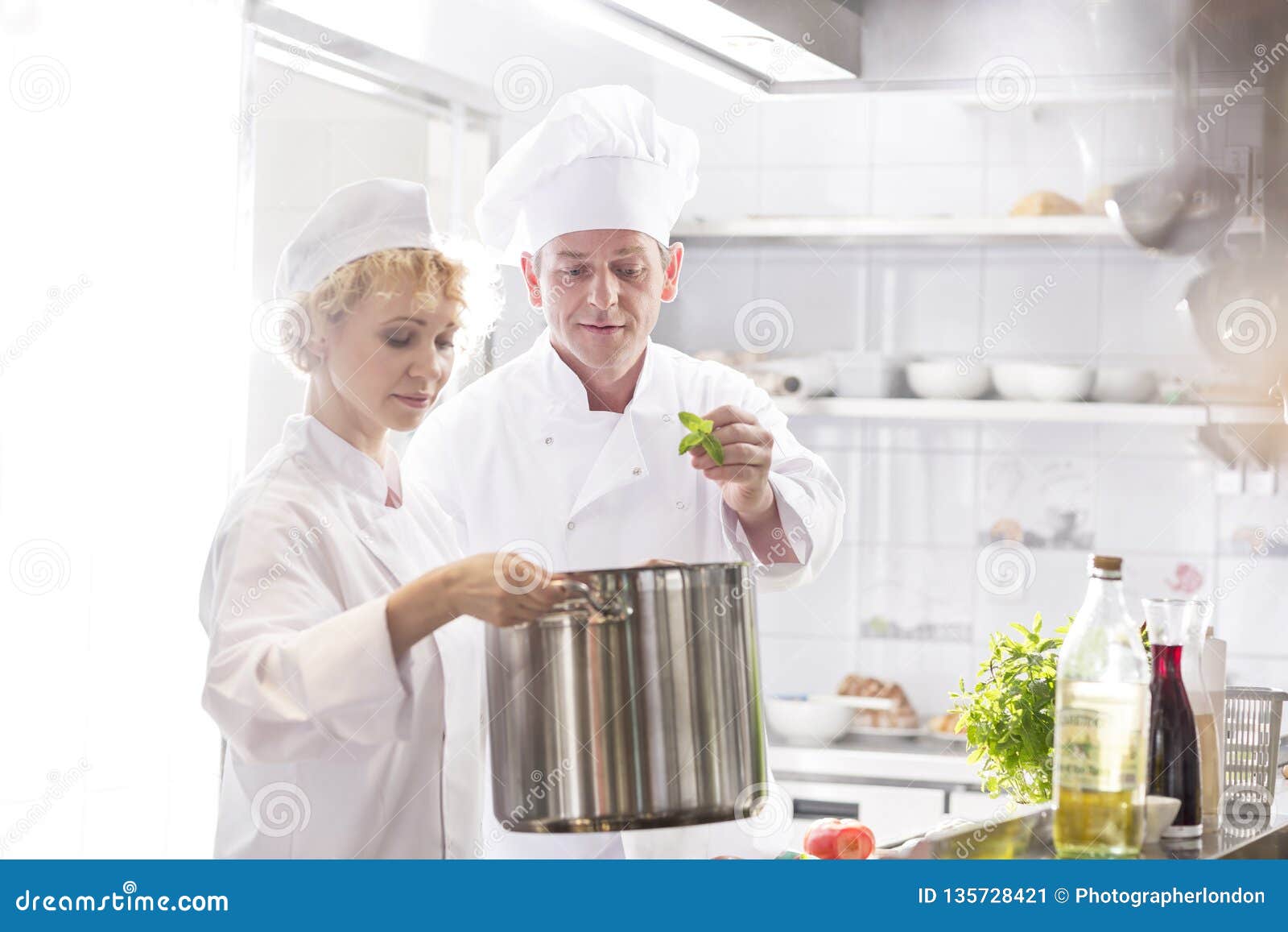 Portrait Of A Mature Chef Cook Holding Knifes Isolated On A Blue Background Stock Photo