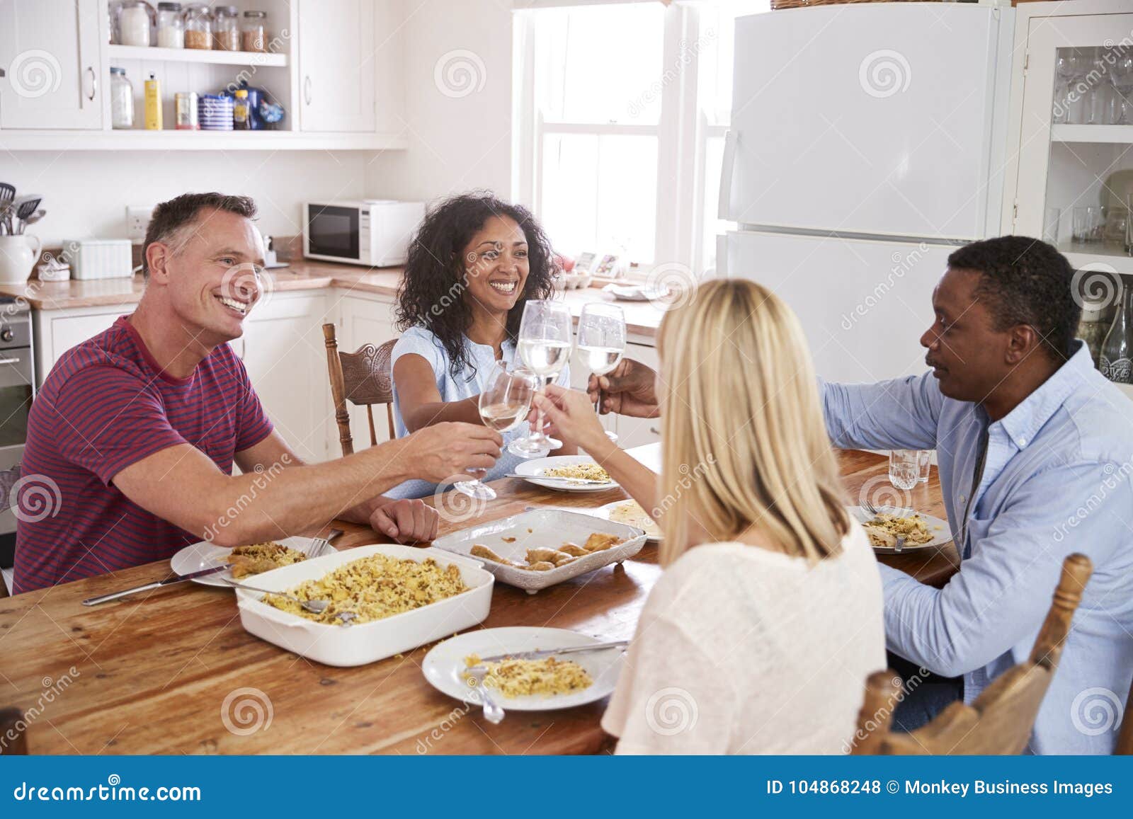 Mature Couple Entertaining Friends At Dinner Party Stock Photo Image