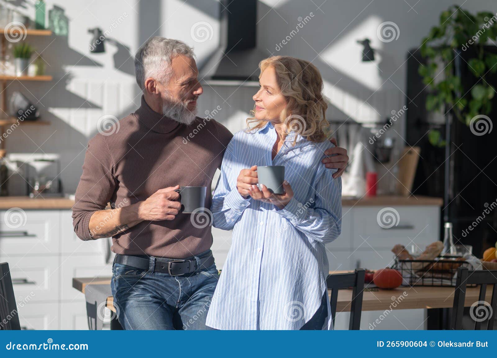 Mature Couple Having Morning Coffee Andtalking In The Kitchen Stock