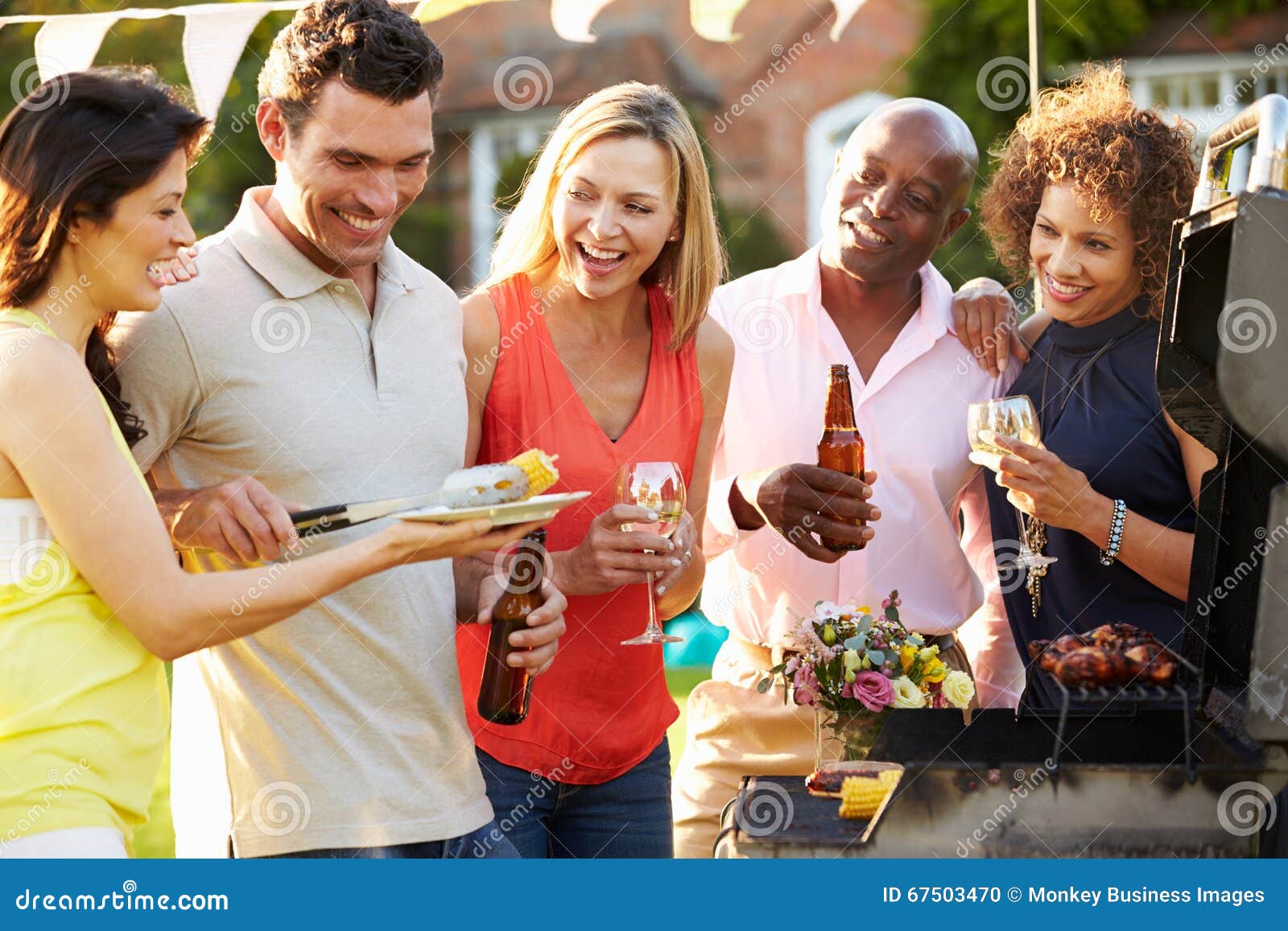 mature friends enjoying outdoor summer barbeque in garden