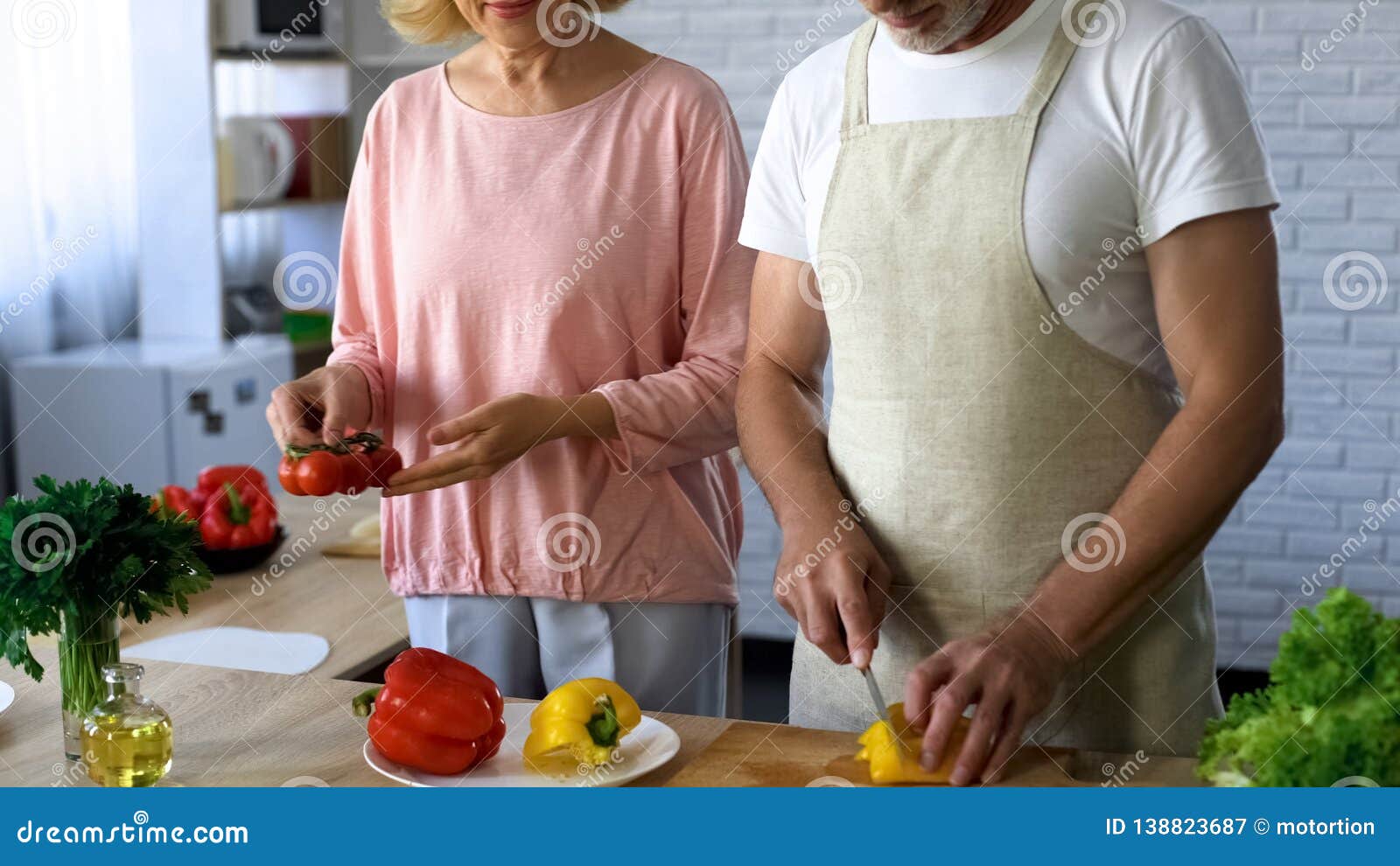 Mature Husband And Wife Cooking Vegetarian Lunch In Kitchen Family