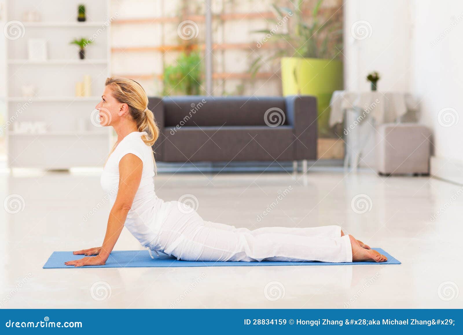 Slim Mature Woman Doing Exercises on Yoga Mat Isolated on White