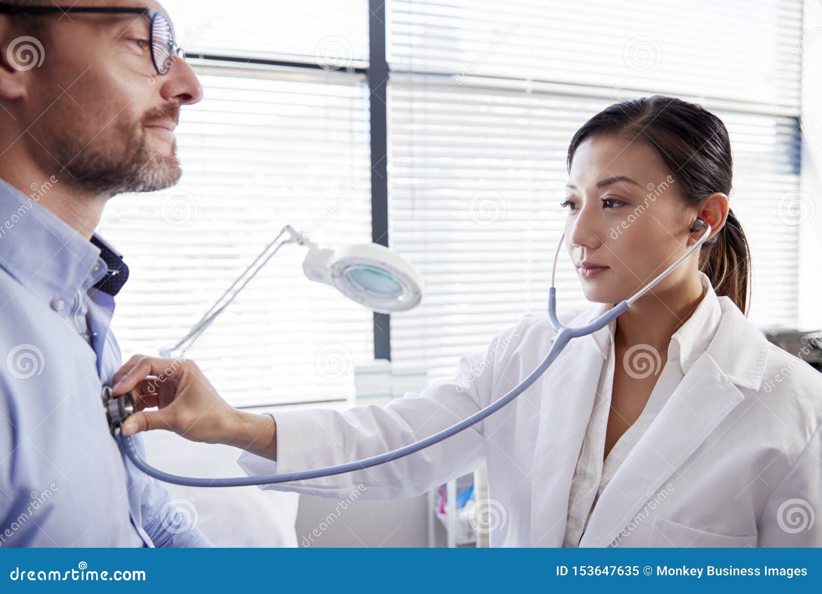 Mature Male Patient Having Medical Exam With Woman Docto