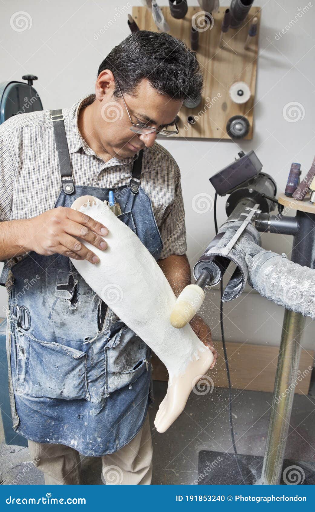 mature male worker buffing prosthetic limb