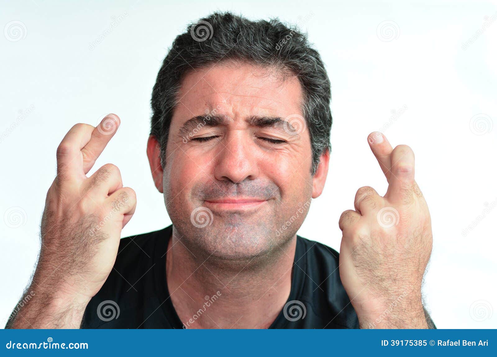 mature man with crossed fingers hoping for luck