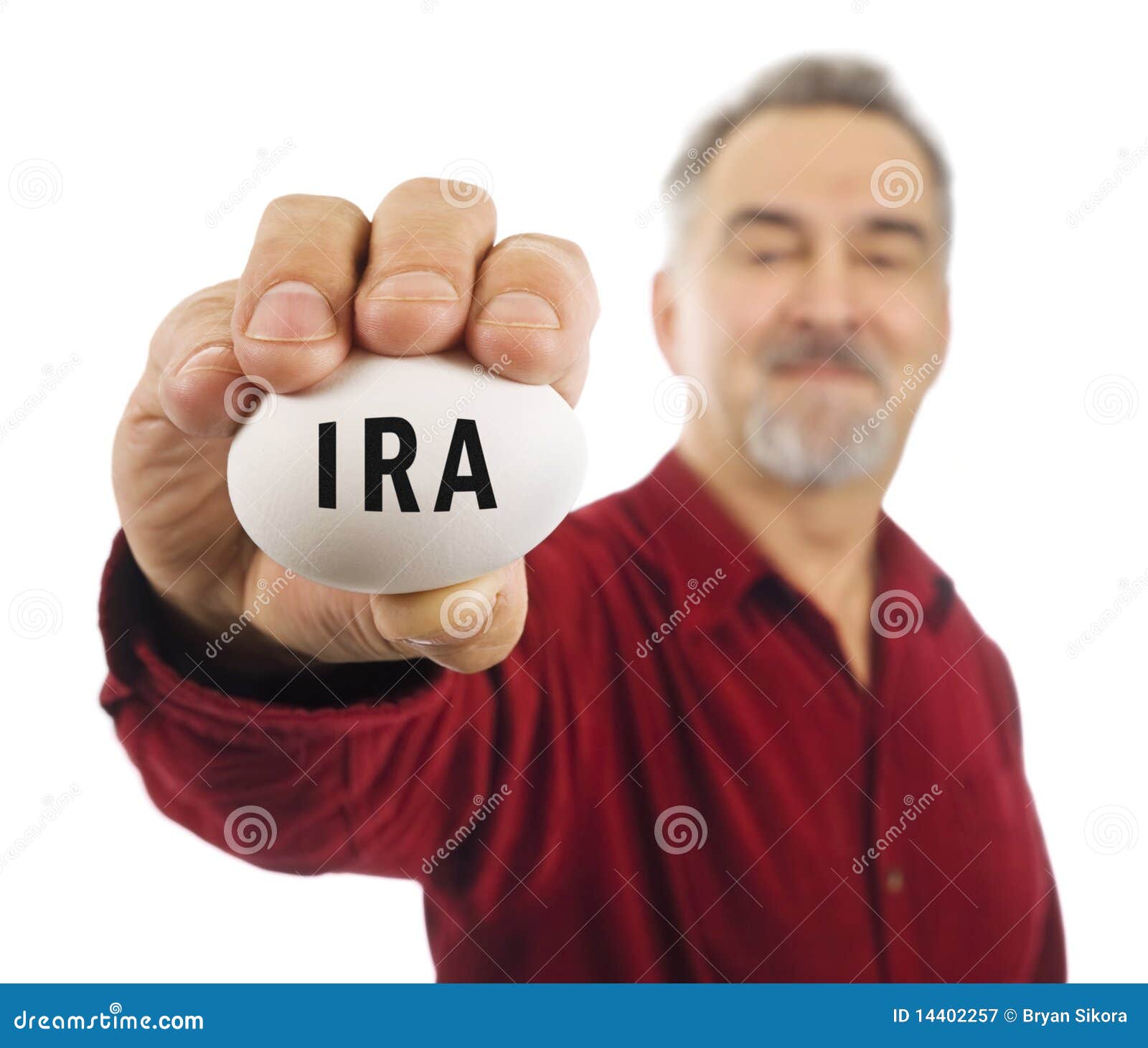 mature man holds white nest egg with ira on it.