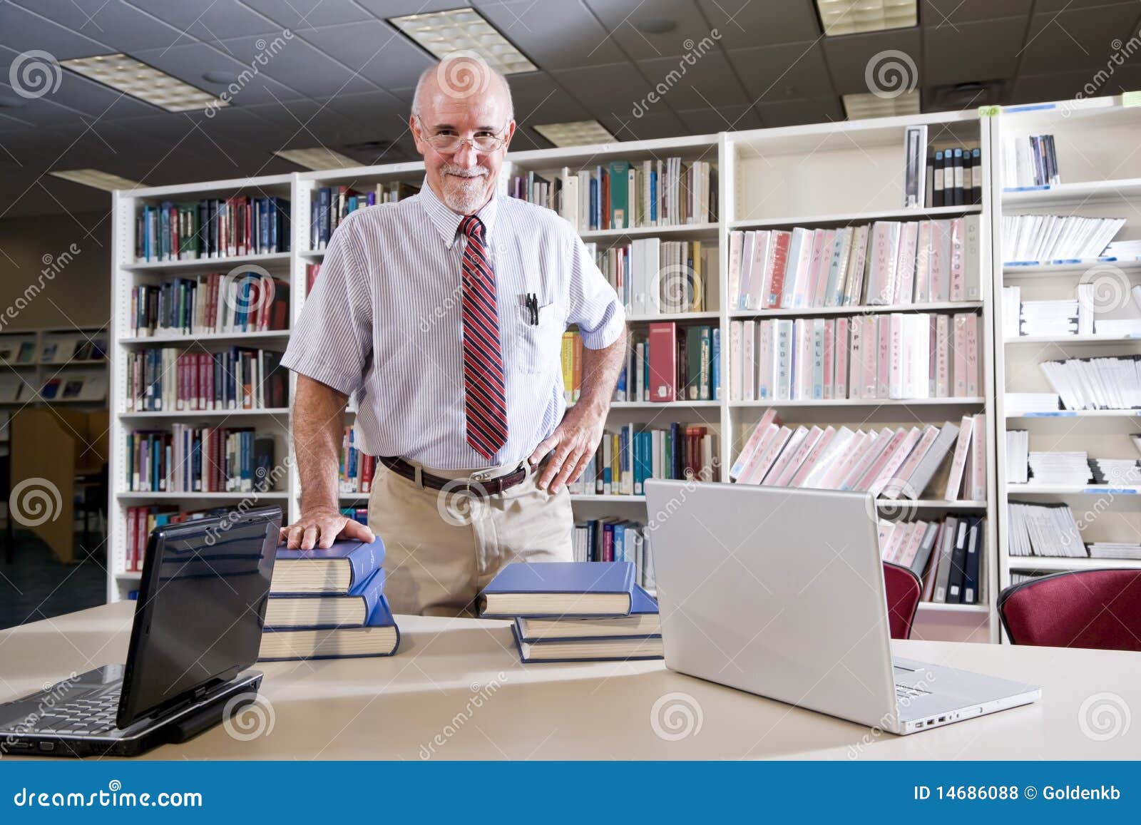 mature man at library table with textbooks