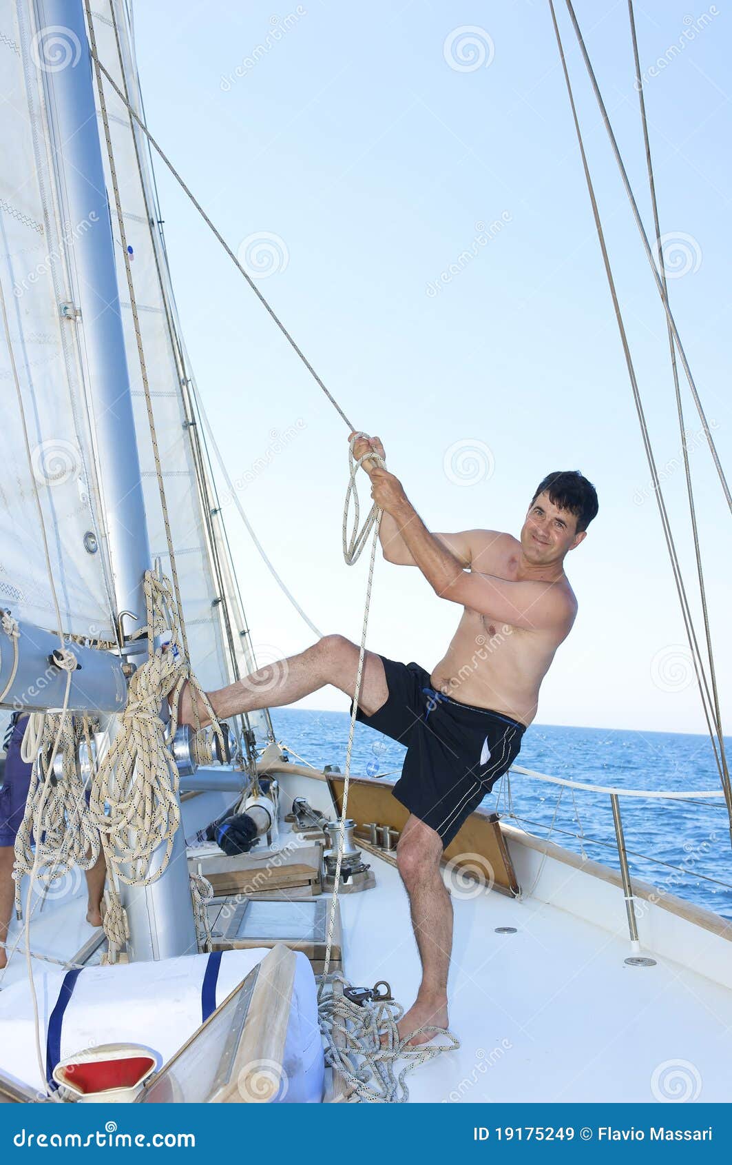 mature man smiling while hoisting the sail