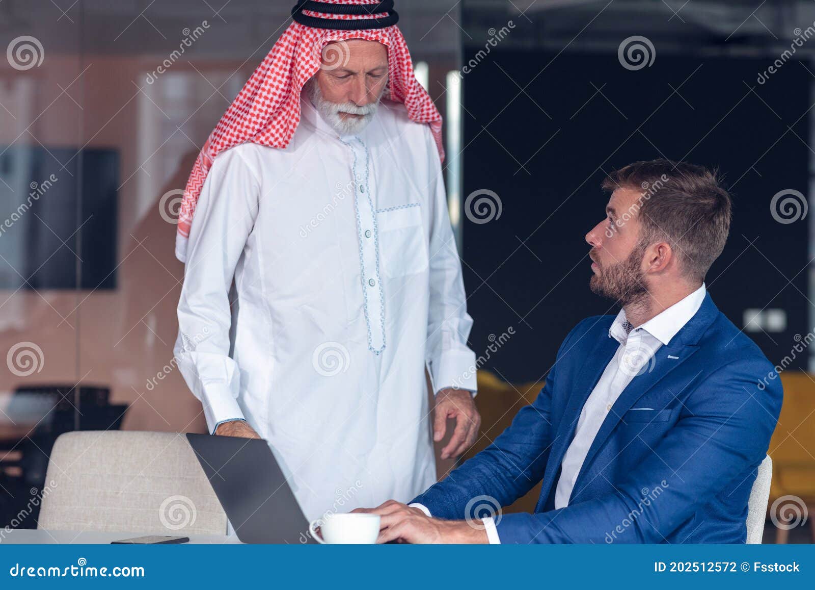 mature middle eastern businessman wearing ghoutra in meeting