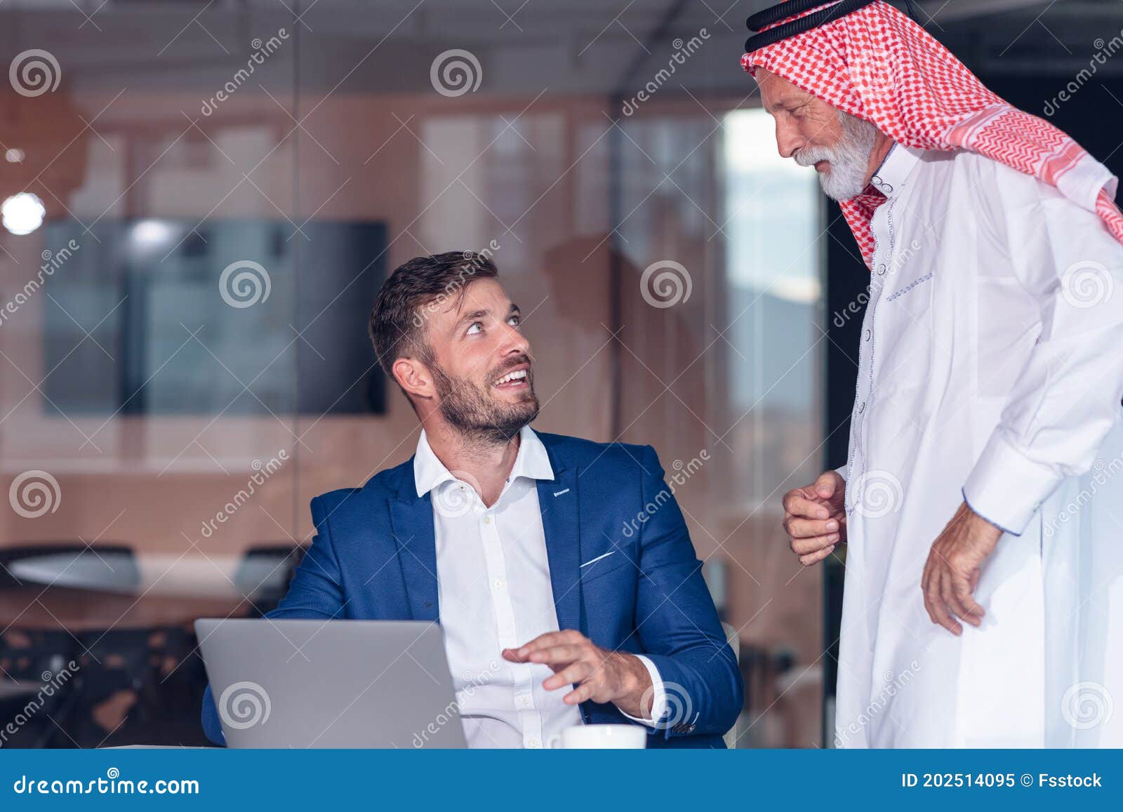 mature middle eastern businessman wearing ghoutra in meeting