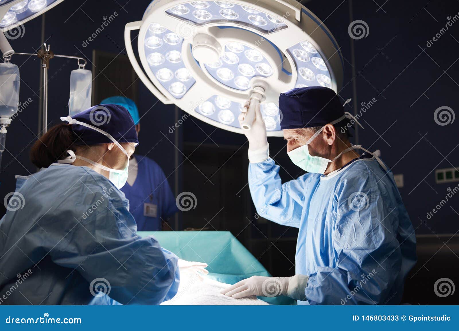 Mature Surgeon Setting the Surgical Light during an Operation Stock