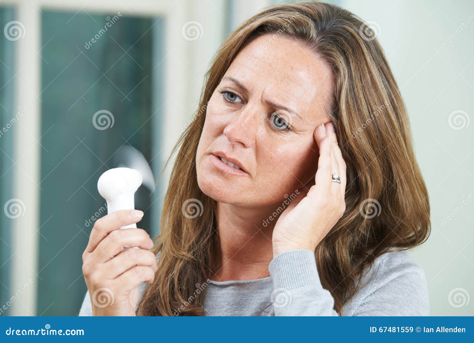 mature woman experiencing hot flush from menopause