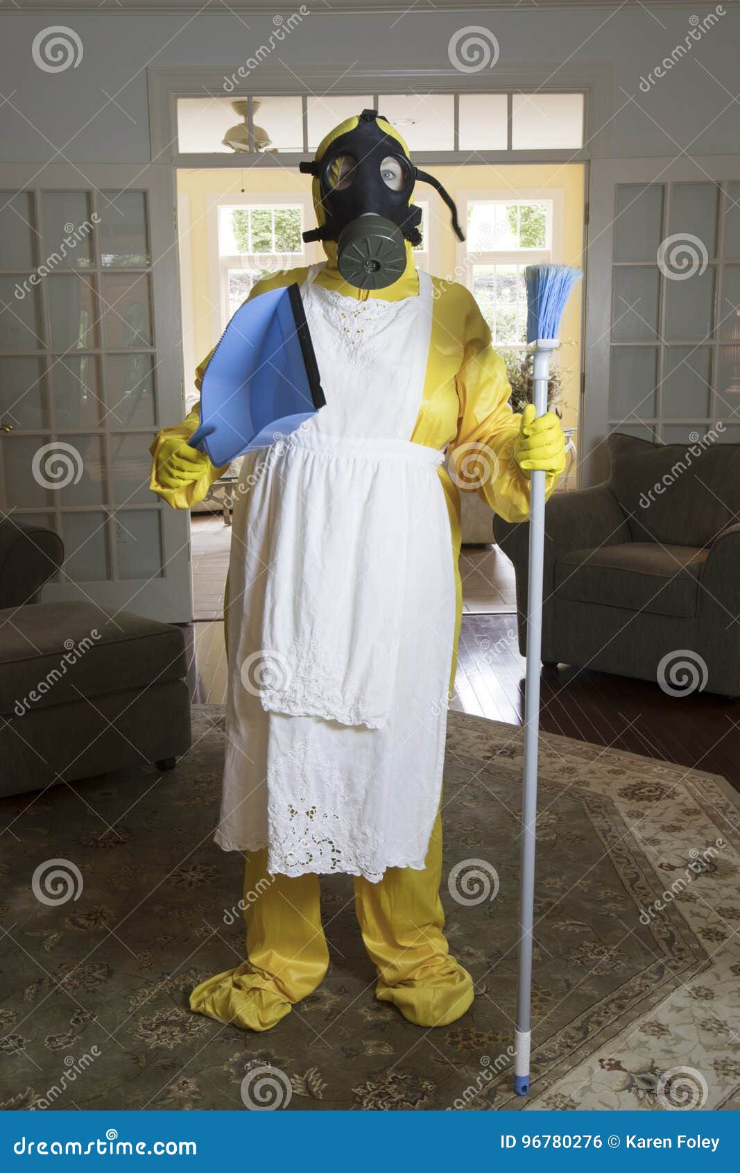 mature woman in haz mat suit with broom and dust pan