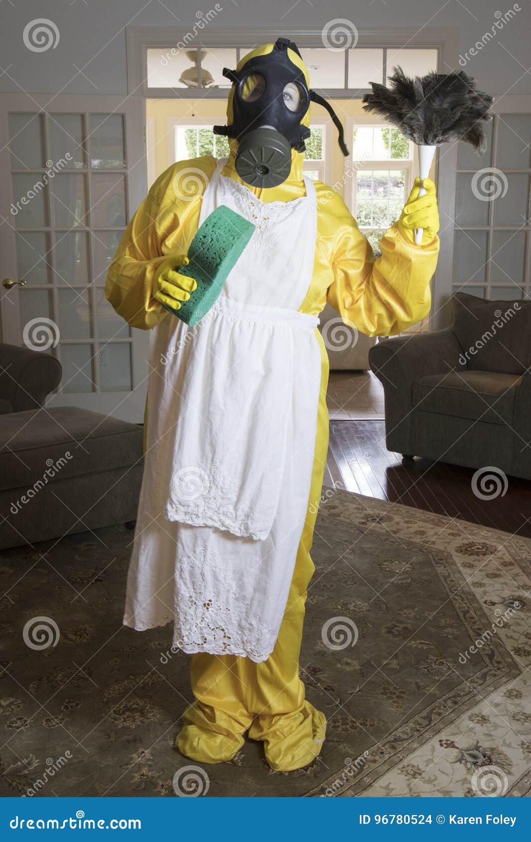 mature woman in haz mat suit with feather duster and sponge